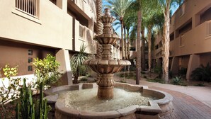A courtyard with a central fountain, palm trees, and a building with balconies. - Sheraton Desert Oasis Villas, Scottsdale (Scottsdale)