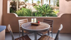 A round table with four chairs, a wooden table, and a view of a rocky landscape with palm trees. - Sheraton Desert Oasis Villas, Scottsdale (Scottsdale)