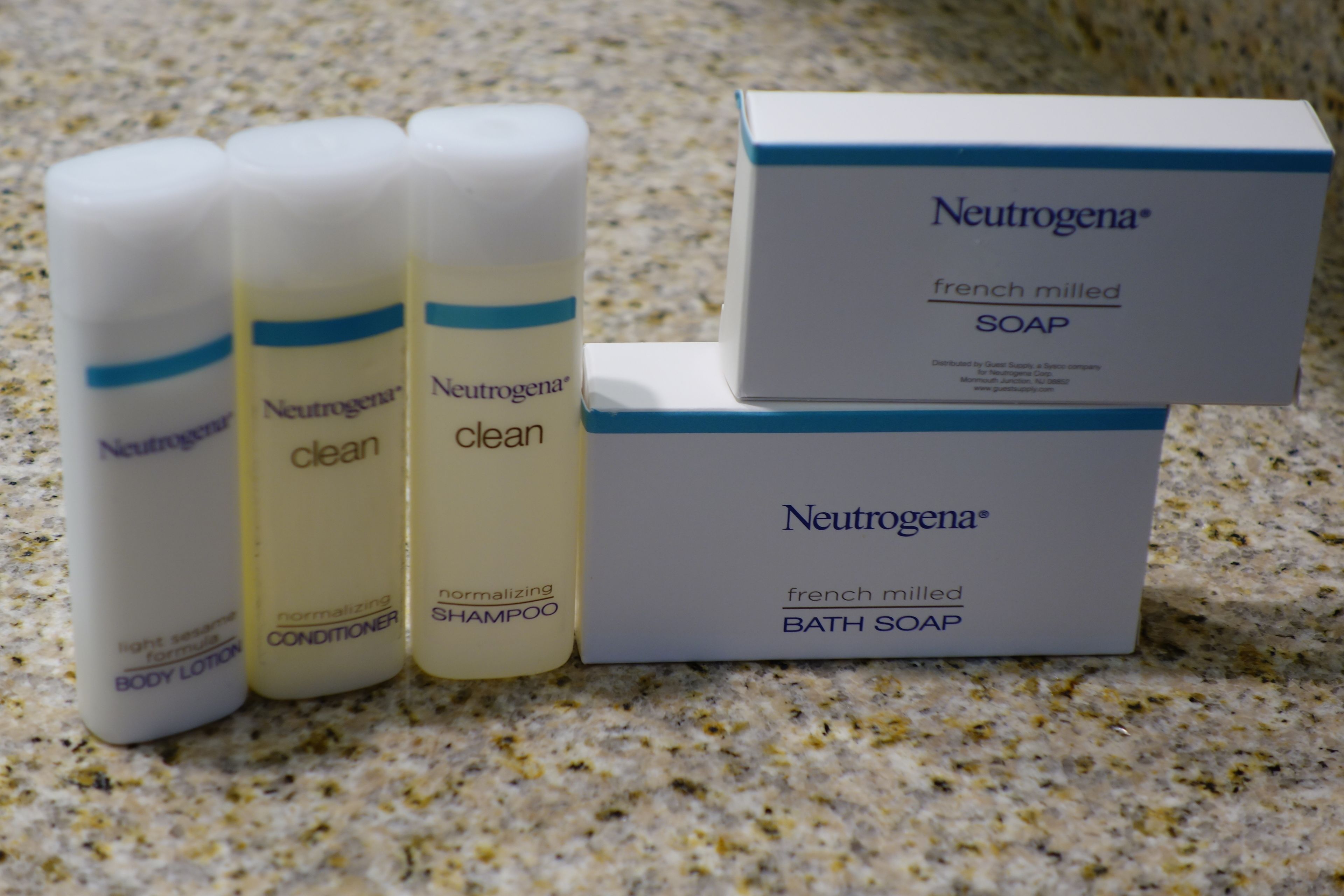 Una caja de jabón de baño y jabón Neutrogena® de fabricación francesa, junto con tres botellas de acondicionador y champú Neutrogena®.