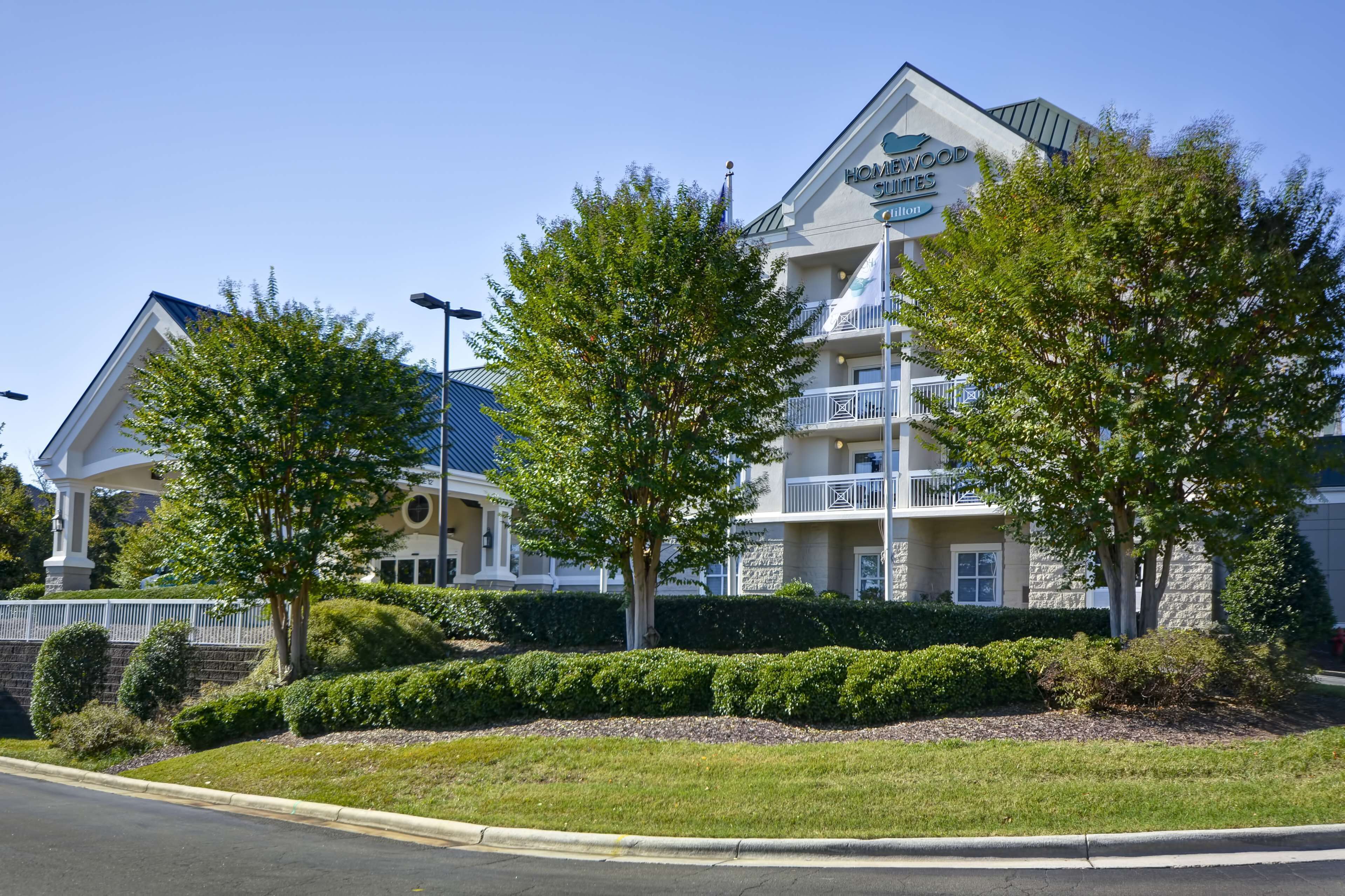 A hotel with a stone facade, multiple balconies, and a clear blue sky.