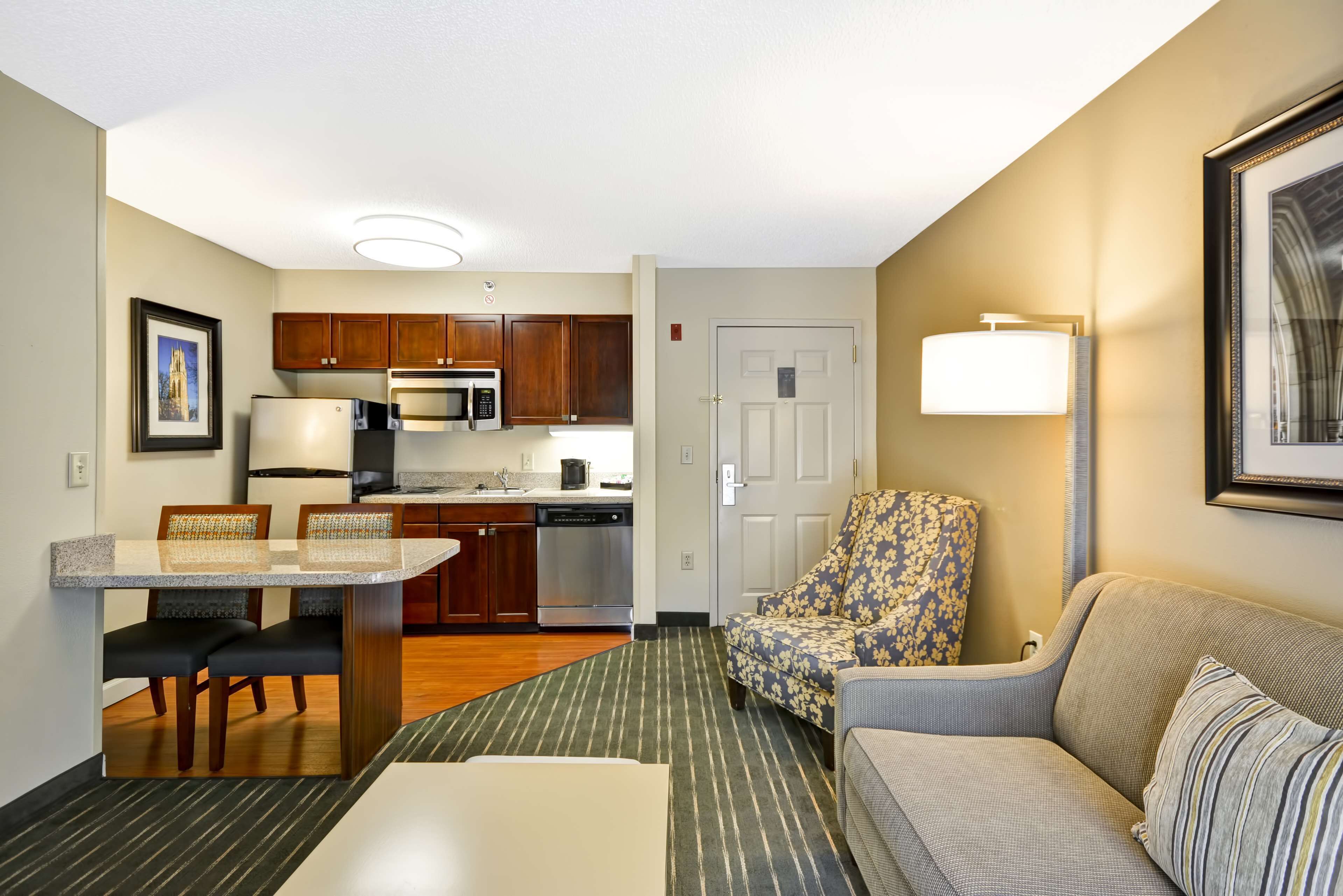 Un espacio habitable compacto con kitchenette, comedor y zona de estar.
