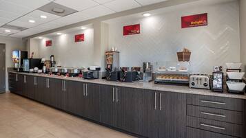 A modern breakfast bar with a variety of food and drink options, including a yogurt station and a coffee machine.