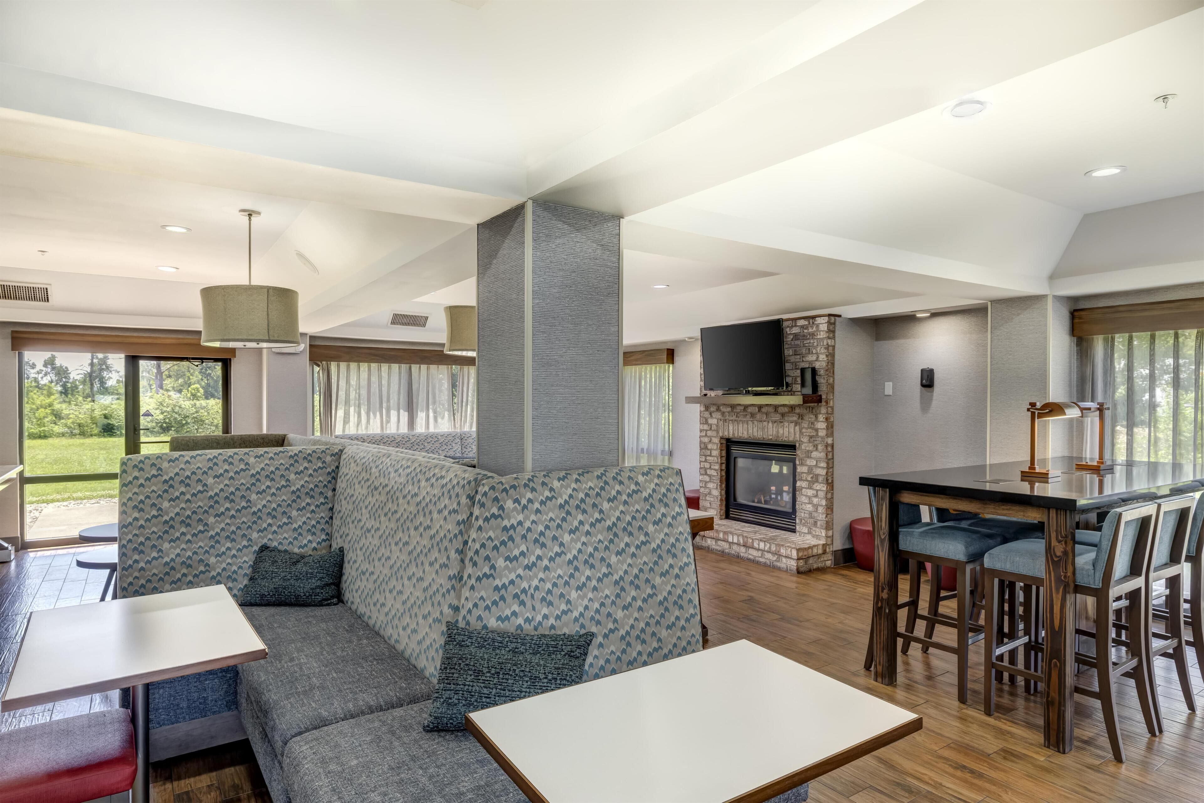 Un interior moderno con un sofá modular, una chimenea, un comedor y un televisor.