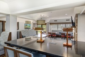 A modern hotel room with a dining area, a sofa set, and a large window. - Hampton Inn Shelbyville (Shelbyville)