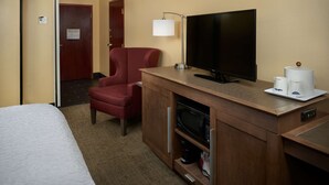 A hotel room with a bed, a red armchair, a TV, a coffee maker, and a microwave. - Hampton Inn Shelbyville (Shelbyville)