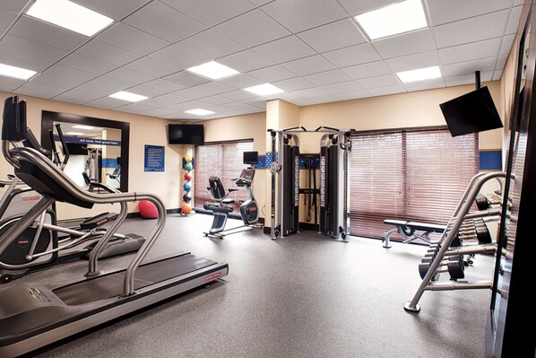 A gym with treadmills, elliptical machines, and weightlifting equipment.