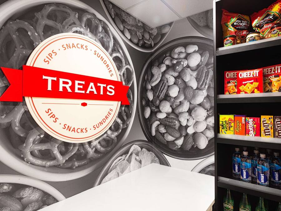 Una bandeja con diversos bocadillos, como papas fritas, nueces y productos envasados.