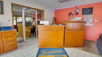 A reception area with a wooden desk, a computer, and a check-in counter.