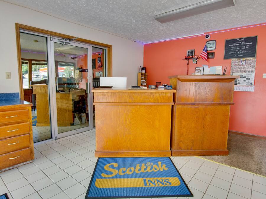 A reception area with a wooden desk, a computer, and a check-in counter.