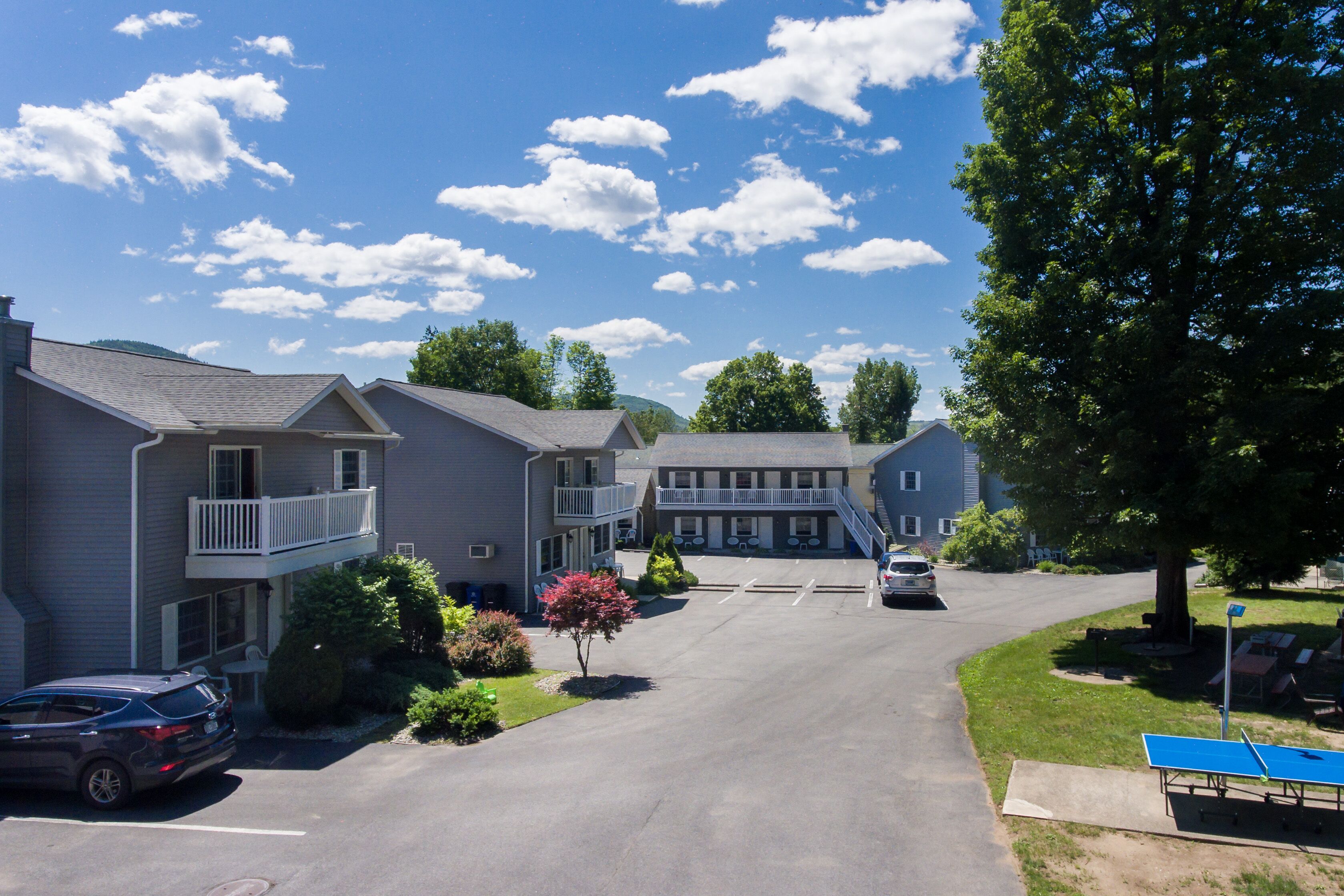A residential building with a central courtyard, a covered walkway, and a parking area.