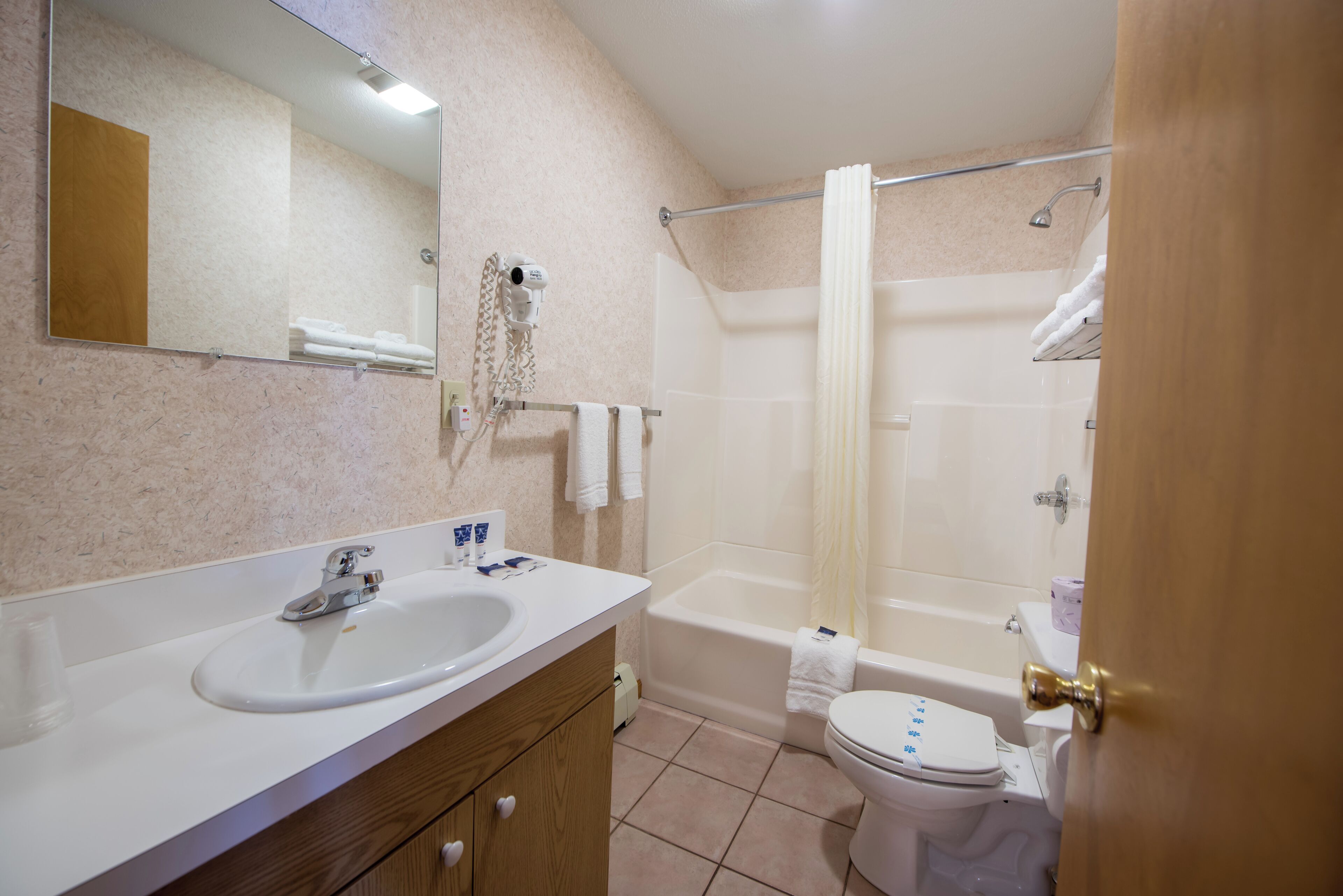 A bathroom with a sink, mirror, and a shower area.