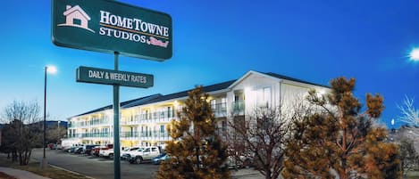Señal de hotel que muestra 'HOMETOWNE STUDIOS' y 'TARIFAS DIARIAS Y SEMANALES'.