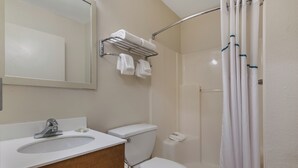 Un baño con lavamanos, inodoro y ducha.