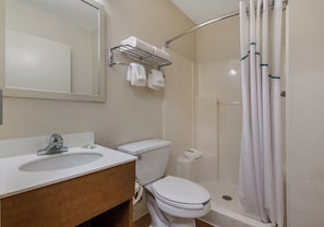 Un baño con lavamanos, inodoro y ducha.