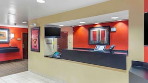 A reception area with a counter, a digital display, and a phone. - Extended Stay America Suites Jacksonville Camp Lejeune (Jacksonville)