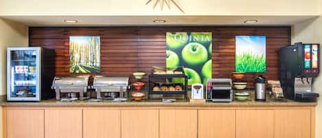 Una barra de desayuno con máquina de café, tostadora y dispensadores de alimentos.