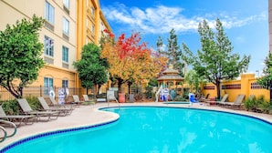 A swimming pool with lounge chairs, a gazebo, and autumn-colored trees. - La Quinta Inn & Suites by Wyndham Fremont / Silicon Valley (Fremont)