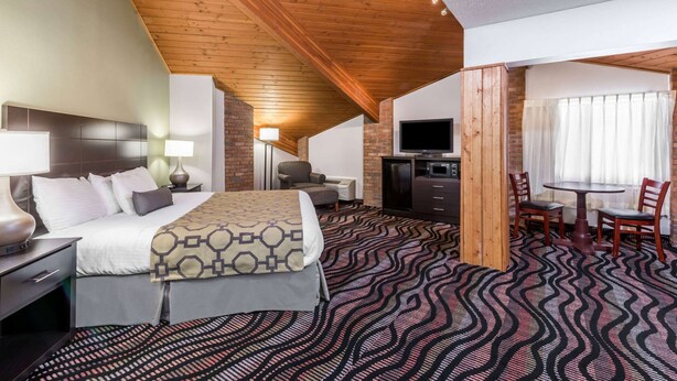 Una habitación de hotel con cama, escritorio, televisión y zona de comedor.