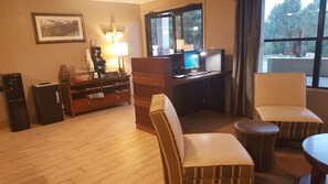 Relax in a well-appointed room with a cozy seating area, desk, and entertainment unit.