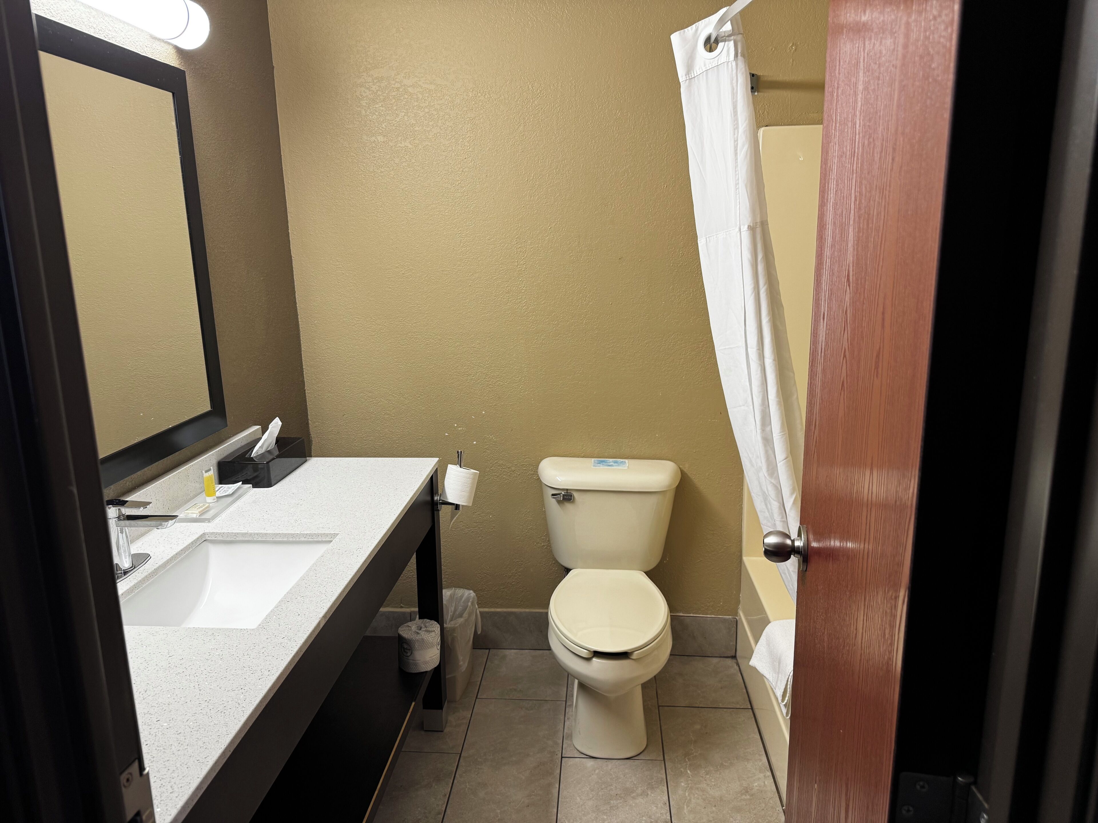 Baño con inodoro, lavamanos y cortina de ducha.