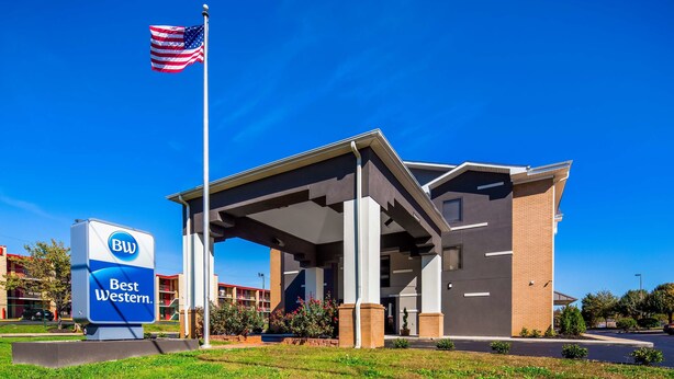 Ein Best Western Hotel mit modernem Design, das eine überdachte Einfahrt und einen strahlend blauen Himmel im Hintergrund zeigt.