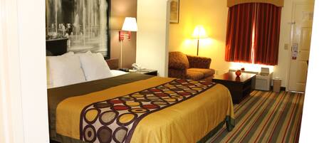 Une chambre d’hôtel avec un grand lit, un bureau, une chaise, une lampe et une fenêtre avec des rideaux.