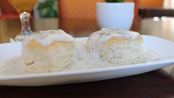Two biscuits with gravy on a white plate.