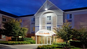 Un hôtel au design moderne, reconnaissable à son panneau bien visible indiquant « Simply Suites ».