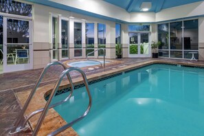 Una piscina techada, sillones reclinables de piscina
