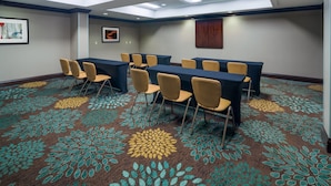 A conference room with a high ceiling, skylights, and a patterned carpet.