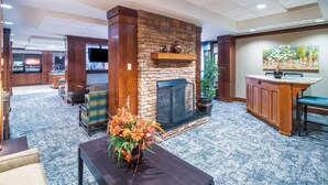 A lobby with a stone fireplace, a reception desk, and a television.