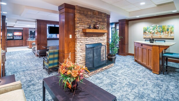 A lobby with a stone fireplace, a reception desk, and a television.