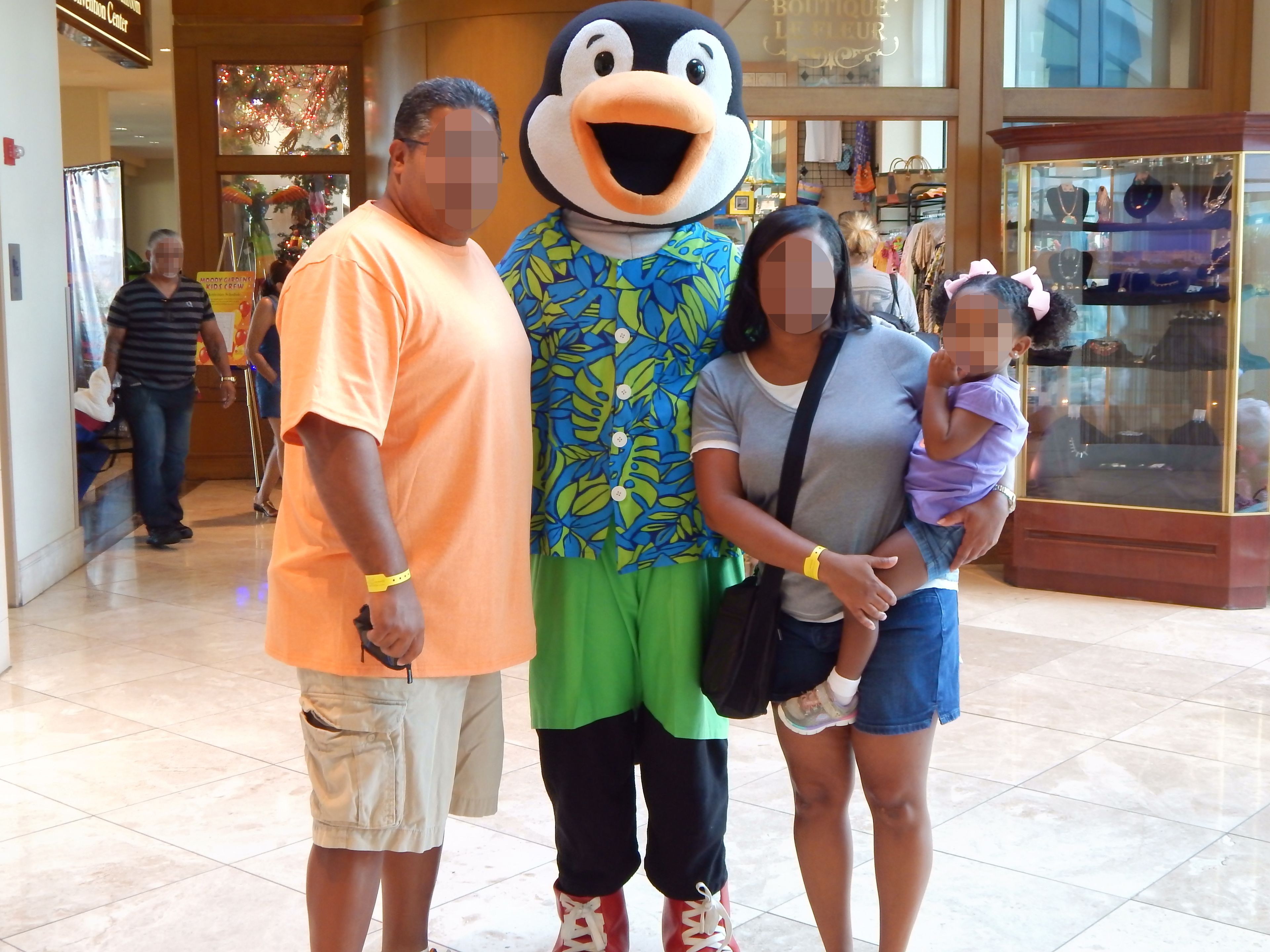 A family with a mascot in a shopping mall.