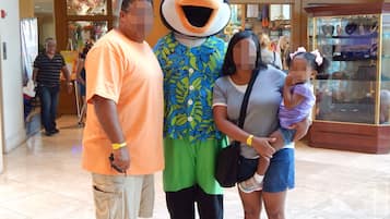 A family with a mascot in a shopping mall.