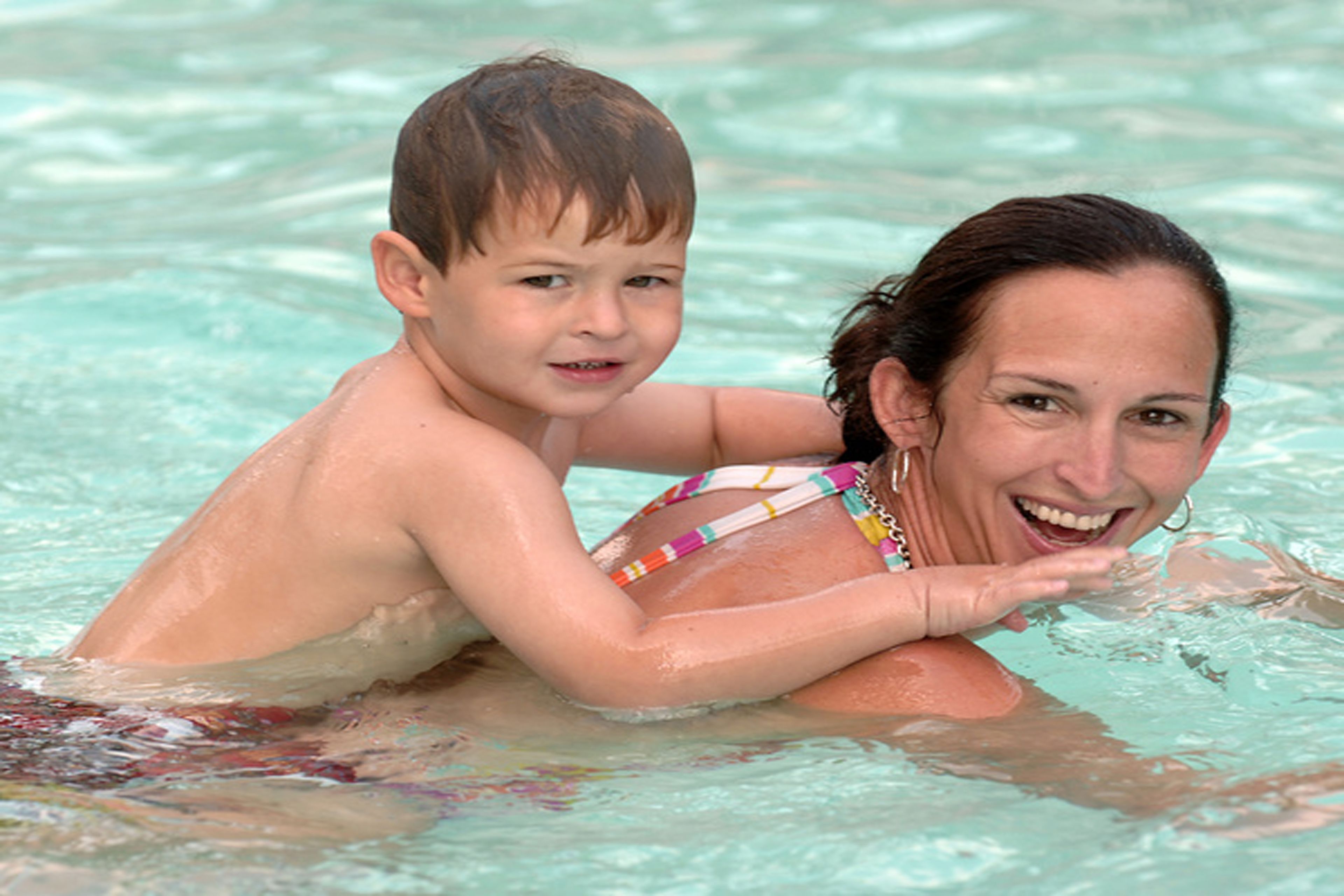 A woman and a child in a swimming pool.