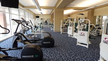 Un gimnasio con cintas de correr, elípticas y máquinas de pesas.