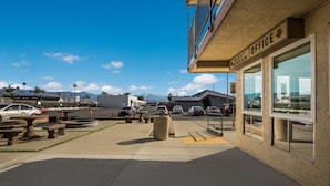 A parking area with a building labeled "NIGHT OFFICE" and a clear view of mountains in the background. - Rodeway Inn San Bernardino - Colton (San Bernardino)