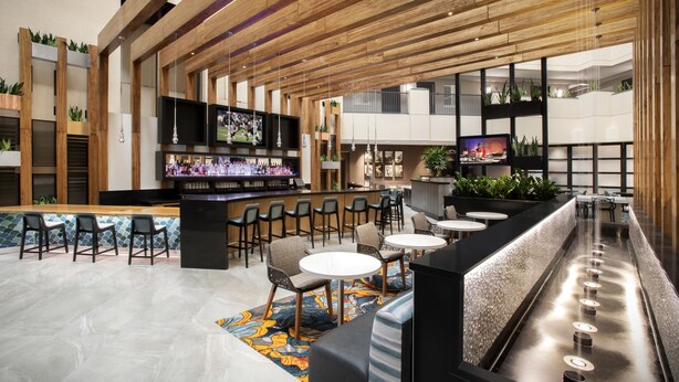 Eine moderne Bar mit Sitzgelegenheiten, Bartresen und Fernsehern.