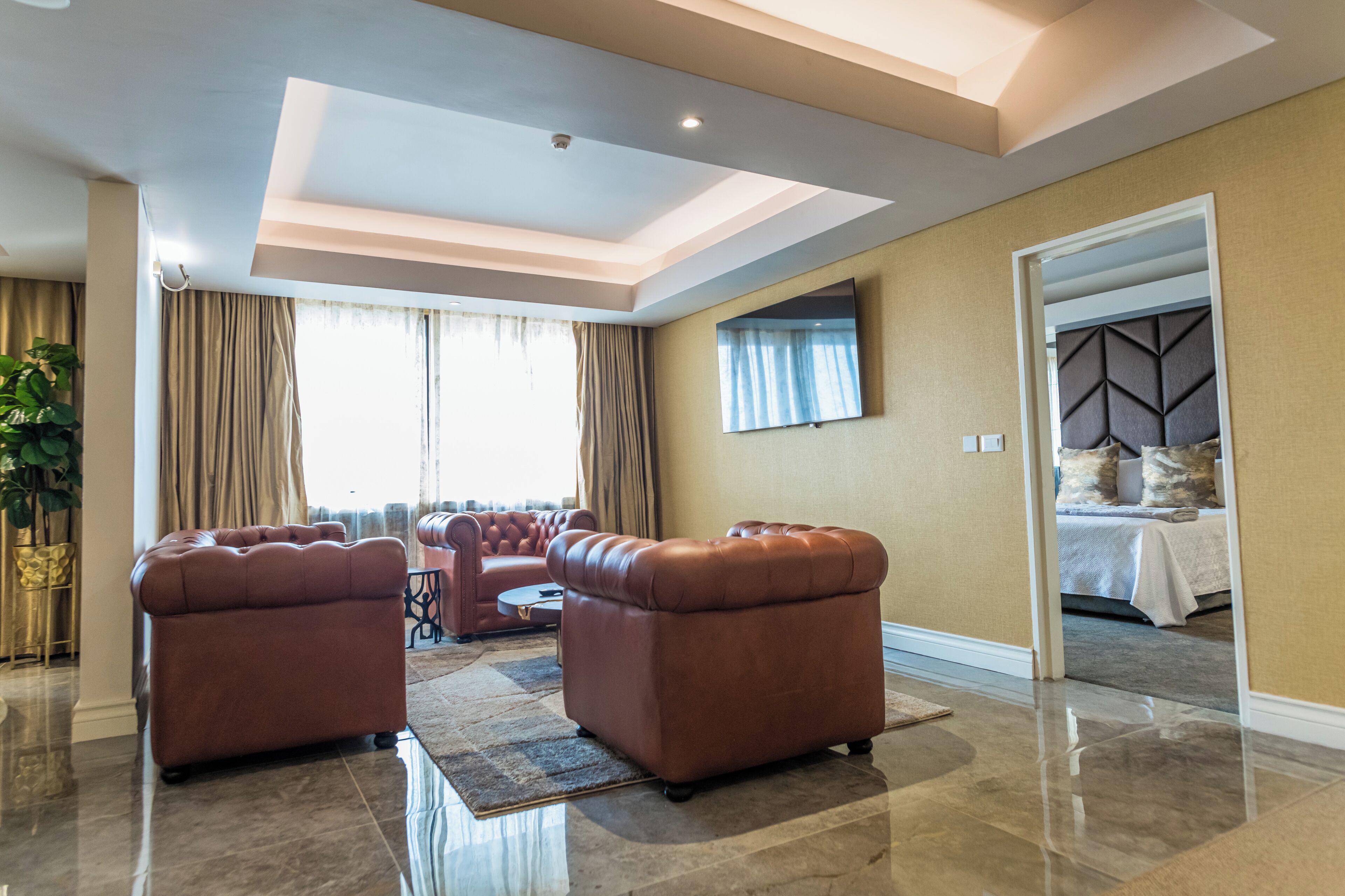 Un salón espacioso con un gran ventanal, un televisor de pantalla plana y una zona de estar confortable.