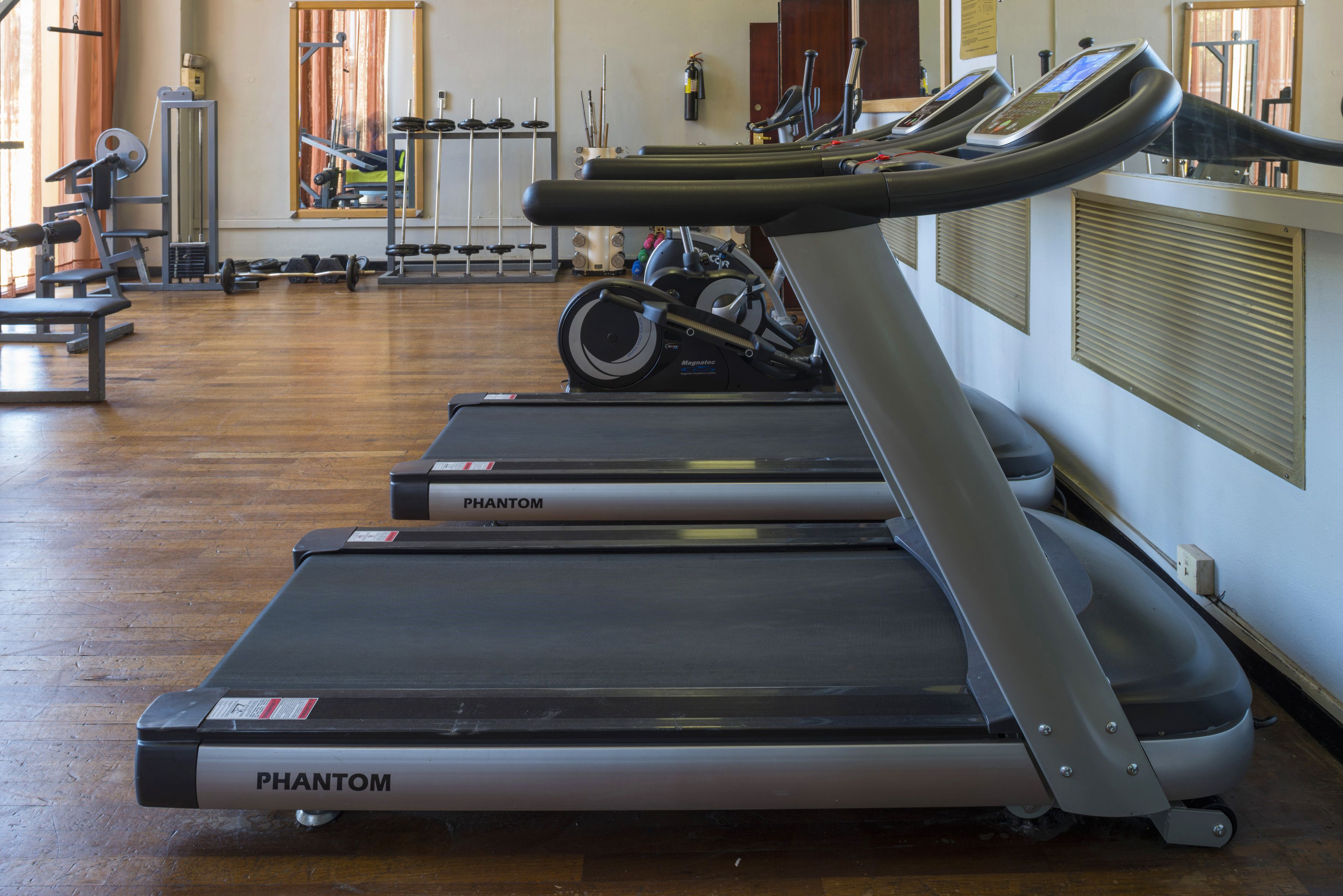 A gym with treadmills, weights, and exercise equipment.