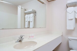 A bathroom with a sink, mirror, and towel rack.