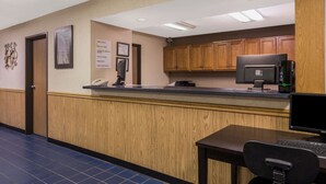 Una zona de recepción con un mostrador de madera, un escritorio y una computadora.
