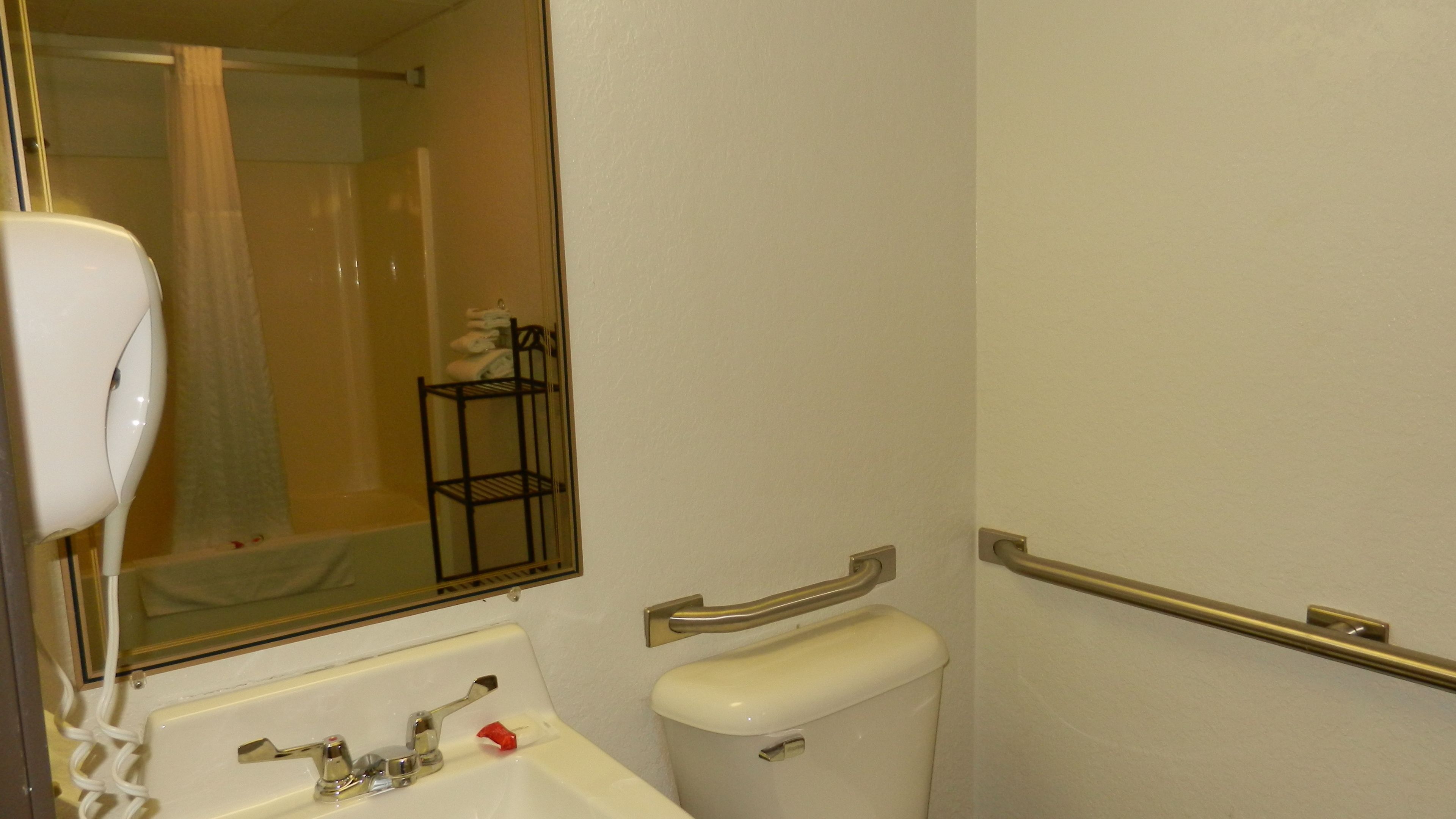 Un baño con un lavabo blanco, un inodoro, un espejo y un perchero para toallas.