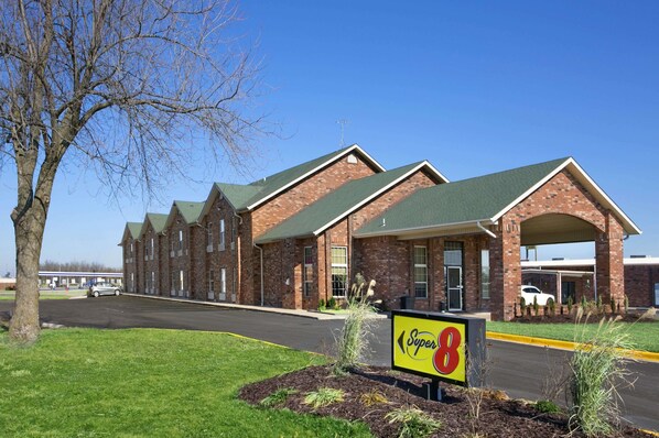 A brick building with a green roof and a sign reading "Super 8".