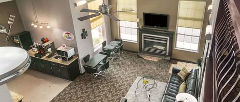 A spacious living area with a fireplace, a dining table, and a sofa.