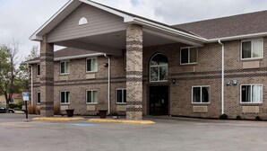 A multi-story brick building with a covered entrance and multiple windows.