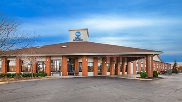 Un hotel Best Western con fachada de ladrillo, amplias ventanas y zona de estacionamiento techada.