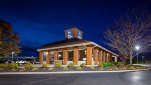 A brick building with a sign reading "Best Western" at night.