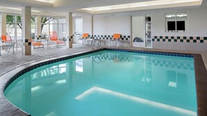 An indoor swimming pool with clear water, surrounded by lounge chairs and a tiled floor. - Hilton Garden Inn Albuquerque North/Rio Rancho (Rio Rancho)