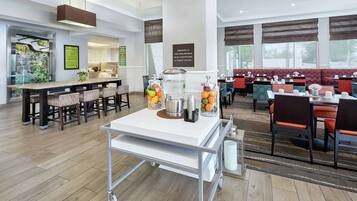A hotel dining area with a buffet setup, seating arrangements, and a non-smoking sign.